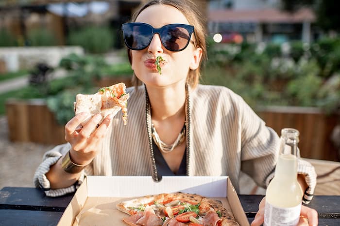 woman-eating-pizza-outdoors